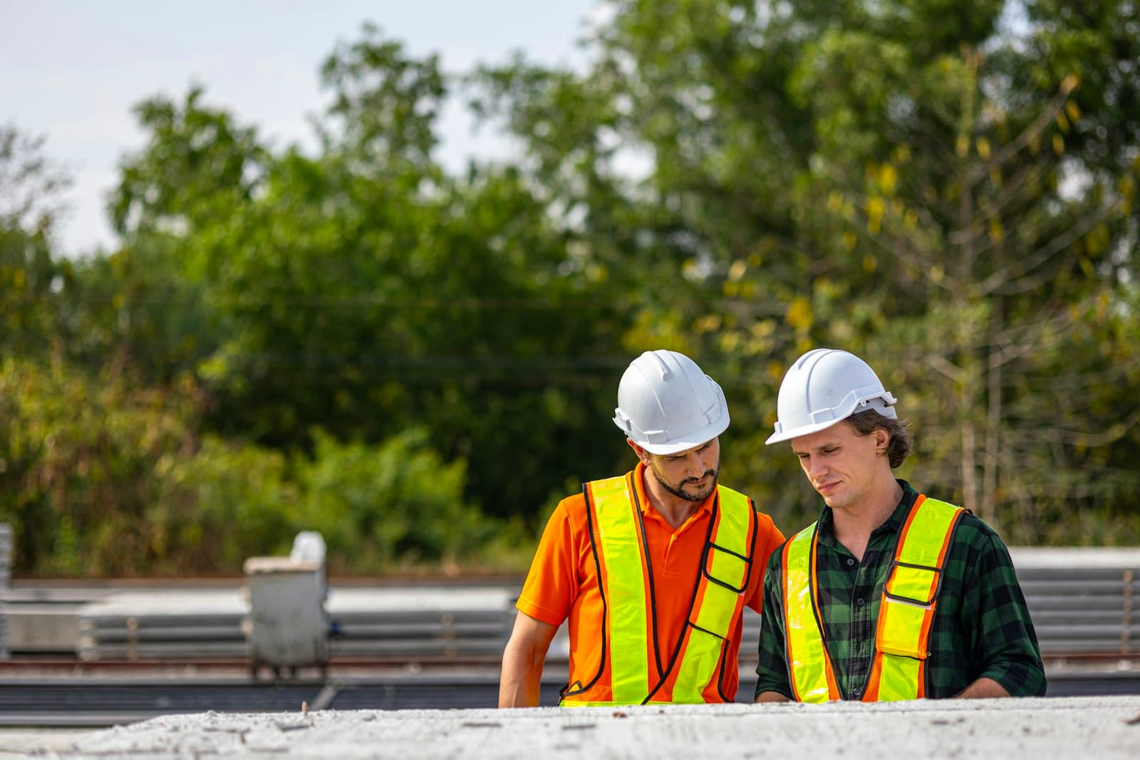 Dois engenheiros inspecionando material de obra juntos